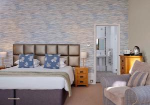 a bedroom with a bed and a couch and a chair at The Falmouth Hotel in Falmouth