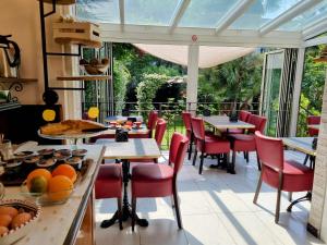 uma sala de jantar com mesas, cadeiras e janelas em Hotel Charly em Milão