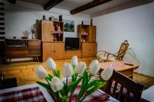 a living room with a table with white flowers at Chalupa KLÁRA -Liptov in Ružomberok