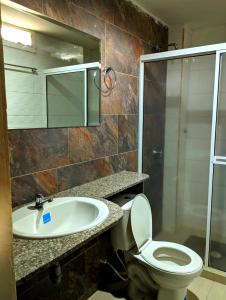 a bathroom with a sink and a toilet and a shower at Villa Cabana Inn in Playa Dormida