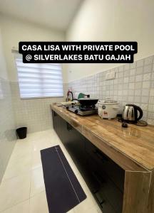Casa Lisa private pool @ Silverlakes BG في باتو جاجاه: مطبخ مع كونتر خشبي في الغرفة