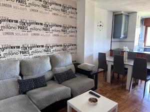 un soggiorno con un divano e un tavolo di Acogedor Apartamento con vistas a la Catedral y parking a Oviedo