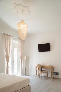 a bedroom with a bed and a desk and a television at VALÚ in Carloforte