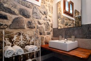 Un baño con lavabo y pared de piedra. en Agriturismo Da Gesi, en Sale Marasino 59 fotos más