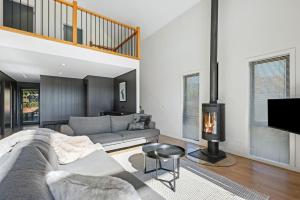 a living room with a couch and a fireplace at Black Tusk - Merrijig - Sleeps 8 in Merrijig