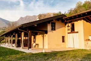 una casa con un porche con montañas al fondo en Agriturismo Da Gesi, en Sale Marasino