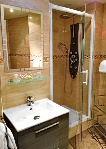 a bathroom with a sink and a shower with a guitar at Hotel Saint-Aignan in Orléans