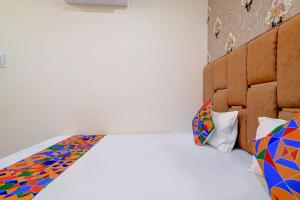 a bedroom with a bed with colorful pillows at FabExpress SK Prime in Ujjain