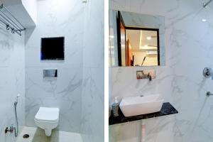 a white bathroom with a toilet and a sink at FabExpress SK Prime in Ujjain