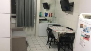 a kitchen with a table with chairs and a television at Boa Vista in Recife