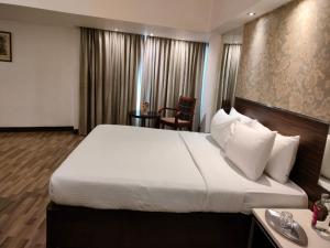 a hotel room with a large bed and a desk at Regenta Place Bangalore, Cunningham Road in Bangalore