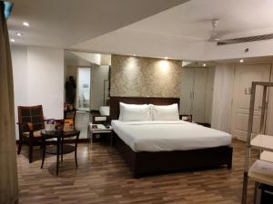 a bedroom with a large bed and a table at Regenta Place Bangalore, Cunningham Road in Bangalore