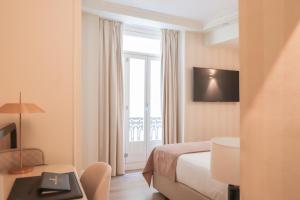 um quarto de hotel com uma cama e uma janela em MYR Palacio Vallier em Valência
