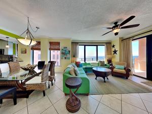 ein Wohnzimmer mit einem grünen Sofa und einem Tisch in der Unterkunft Seachase 701c in Orange Beach
