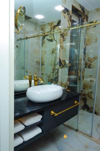 uma casa de banho com um lavatório e uma cabina de duche em vidro. em Dondar Hotel Formula 1 View em Baku