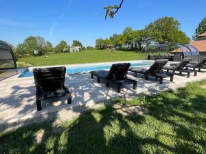a group of chairs sitting next to a swimming pool at La Millière - Piscine & campagne - Bonchamps in Le Poiré-sur-Vie