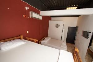 Habitación pequeña con 2 camas y nevera. en Hotel flamencamarones en Camarones