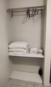 un placard blanc avec une étagère et des serviettes pliées dans l'établissement Boa Vista, à Récife