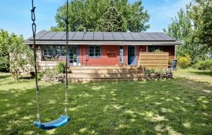 a swing in front of a small house at Cozy Home In Korsør With Kitchen in Korsør +4 photos