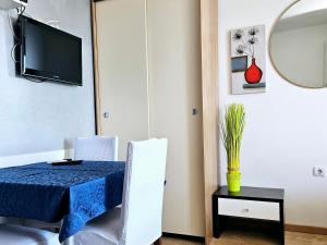 een eetkamer met een tafel en stoelen en een tv bij Apartments Casablanca in Podstrana