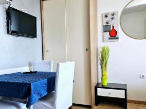 a dining room with a table and chairs and a tv at Apartments Casablanca in Podstrana