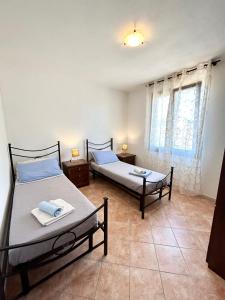 1 Schlafzimmer mit 2 Betten und einem Fenster in der Unterkunft Il tramonto tra Alghero e Stintino in Palmadula