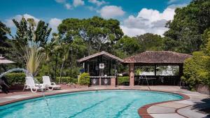 圣希尔Hotel Campestre Casona del Camino Real的一个带椅子的游泳池和一个凉亭