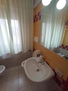 卡拉利貝羅托的住宿－S'Ustiarvu，一间带水槽、卫生间和镜子的浴室