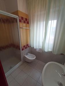 uma casa de banho com um chuveiro, um WC e um lavatório. em S'Ustiarvu em Cala Liberotto