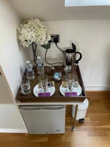 einen Tisch mit Brille und eine Vase auf einem WC in der Unterkunft The Corner House in Rochester