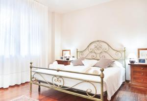 um quarto com uma cama branca com uma estrutura de metal em Casa di Wanni em Treviso