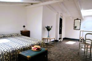 a bedroom with a bed and a table and chairs at Il giardino dei limoni casa nel Borgo in Maranola