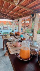 una mesa con platos de comida y bebidas. en Pousada rancho sol nascente, en Tutóia