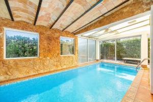 una piscina cubierta con una pared de piedra en Villa Malik mit Meerblick und Pool, en Cala d´Or