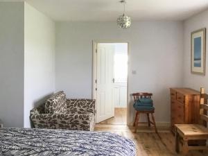 a bedroom with a bed and a chair and a door at Hempstead End in Lessingham