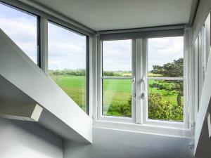 a window in a room with a view of a green field at Hempstead End in Lessingham