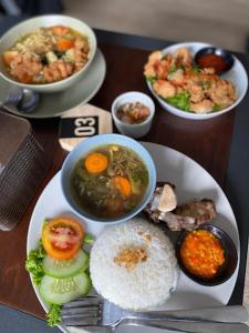 uma mesa com pratos e tigelas de comida em NYENYAK MRT Lebak Bulus Simatupang em Jakarta