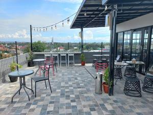 an outdoor patio with tables and chairs and tables and chairs at NYENYAK MRT Lebak Bulus Simatupang in Jakarta