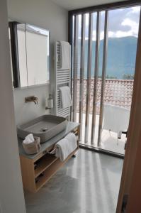 uma casa de banho com um lavatório e uma grande janela em Boutique Hotel La Rocca em Ronco sopra Ascona