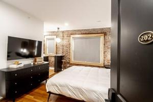a bedroom with a bed and a brick wall at Heart of Downtown, Walk to Bathhouses, Restaurants Room # 202 in Hot Springs