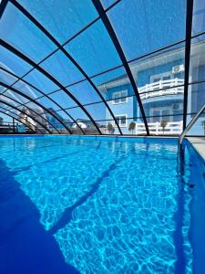 an indoor swimming pool with blue water at Willa Azul - Podgrzewany basen, klimatyzacja w całym obiekcie in Sarbinowo