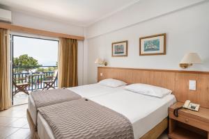 a hotel room with a bed and a balcony at Danae Hotel in Egina