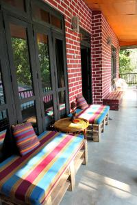 eine Veranda mit Bänken, einem Tisch und Fenstern in der Unterkunft Summer Villa Ella in Ella