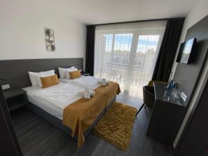 チョパクにあるHOTEL CSOPAK Resort & Lakeのベッドと大きな窓が備わるホテルルームです。