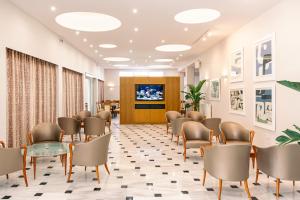 Danae Hotel في ايجينا تاون: غرفة انتظار في مستشفى مع كراسي وطاولات