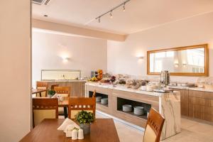 a large kitchen with a table and chairs at Danae Hotel in Egina