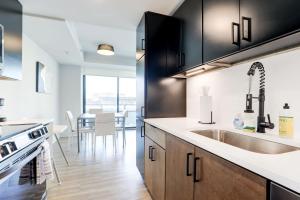 een keuken met zwarte kasten en een wastafel bij 2BR Executive Apartment in Prime Location in Arlington