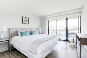 een witte slaapkamer met een groot bed en een bureau bij 2BR Executive Apartment in Prime Location in Arlington