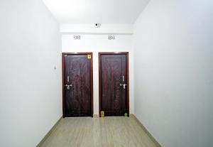 twee houten deuren in een kamer met een houten vloer bij OYO Hotel Grand Eden in Calcutta