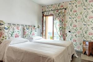 2 camas en un dormitorio con papel pintado con motivos florales en Al Gelso Bianco en SantʼAppiano